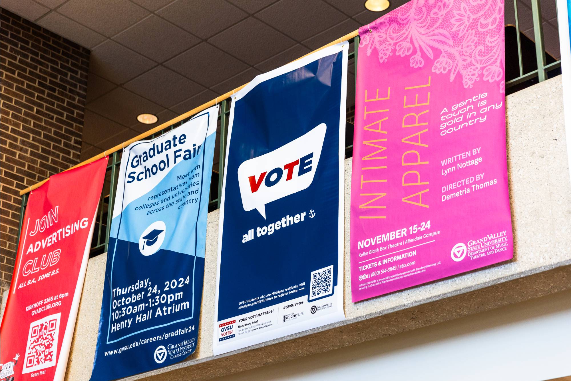 Four banners hanging from a railing